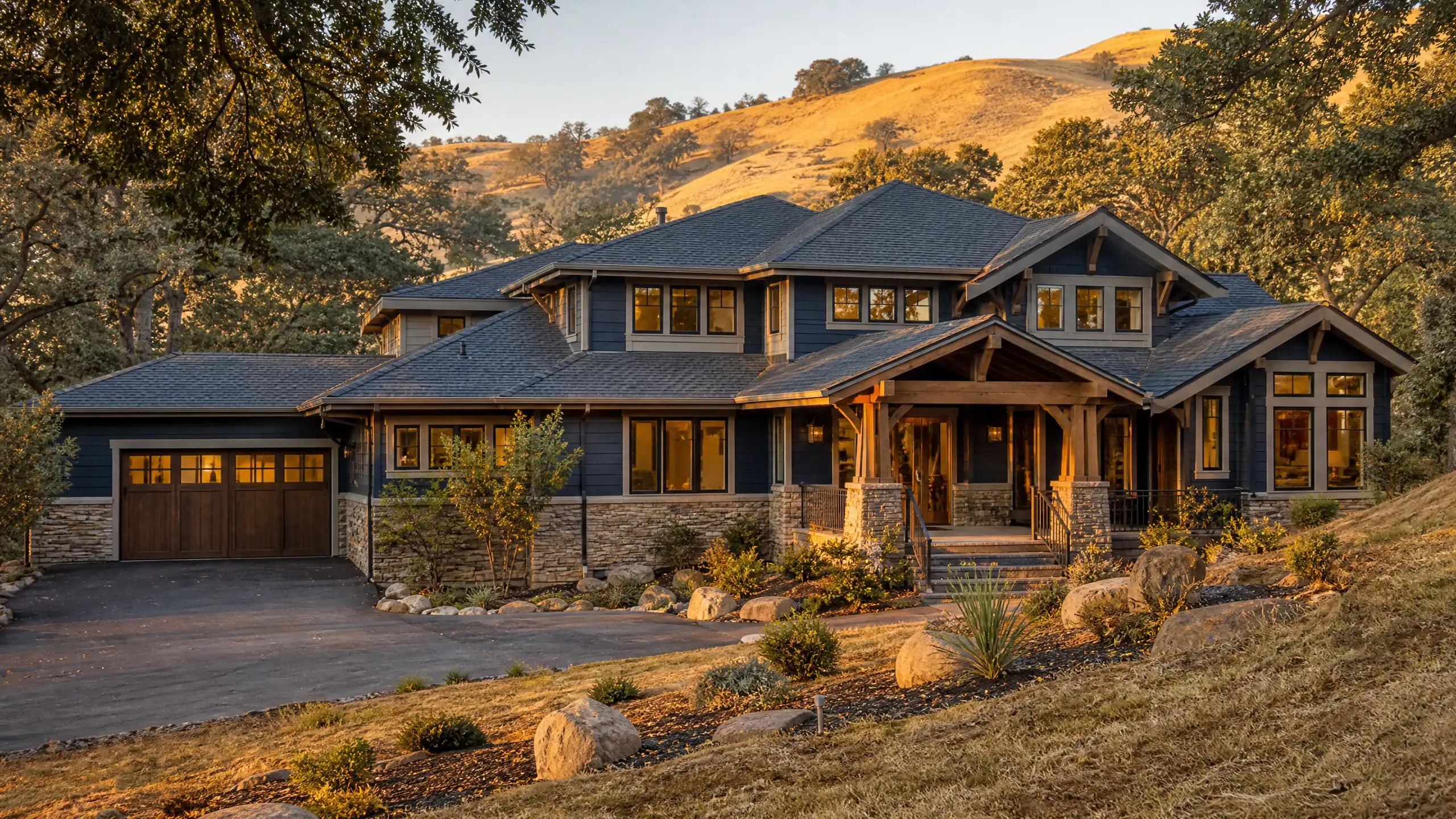 Two-story craftsman-style home with oak trees and golden hills behind it
