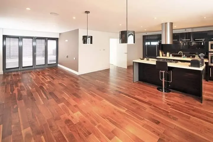 Open-plan living area with hardwood flooring and a dark kitchen island
